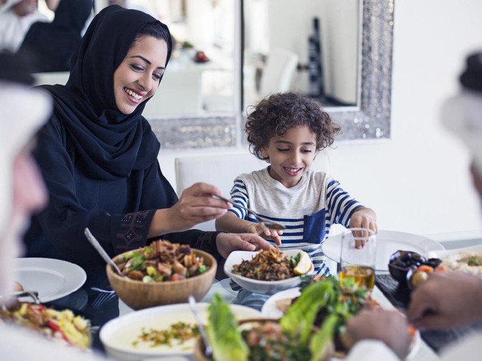 1127348243 Asian family lunch outdoors, children having fun at table, Father helps feed daughter