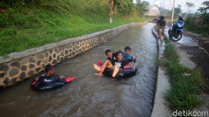 Sejumlah anak-anak mengisi waktu luanganya dengan bermain di saluran irigasi sambil menunggu berbuka puasa di Desa Hegarmanah, Sumedang, Jawa Barat.