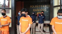Ketiganya kompak menggunakan baju tahanan berwarna oranye.