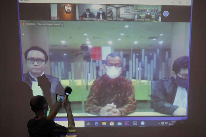 SIDANG VONIS KASUS EMIRSYAH SATAR Tayangan video conference (vicon) yang menayangkan terdakwa mantan Dirut Garuda Indonesia Emirsyah Satar (kedua kiri) menjalani sidang pembacaan putusan di gedung KPK, Jakarta, Jumat (8/5/2020). Majelis hakim memvonis Emirsyah Satar dengan hukuman delapan tahun penjara dan denda Rp1 Miliar subsider tiga bulan kurungan serta membayar uang pengganti sekitar 2,1 juta dolar Singapura subsider dua tahun kurungan karena terbukti menerima suap atas pembelian 50 mesin Roll-Royce untuk pesawat Airbus SAS pada PT Garuda Indonesia periode tahun 2005-2014. ANTARA FOTO/Reno Esnir/wsj. *** Local Caption ***