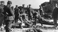 Relawan Palang Merah Jerman menolong tentara Inggris yang terluka saat perang 1917. General Photographic Agency/Getty Images.