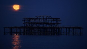 Supermoon tampak cantik saat berada tepat di atas Dermaga Istana pada 7 Mei 2020 di Brighton, Inggris. Getty Images/Mike Hewitt