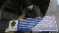 Kru bus menempelkan stiker angkutan AKAP terbatas.