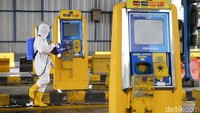 Petugas menyisir lokasi gerbang Tol Cengkareng untuk melakukan operasi disinfeksi.