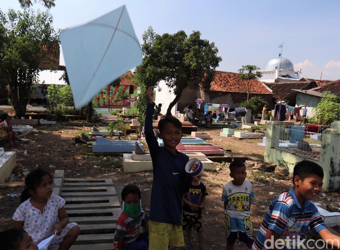 Potret Anak-anak Mengisi Waktu Sambil Bermain Layang-layang di TPU Anak-anak di Bandung bermain layang-layang untuk mengisi waktu di akhir pekan. Tak jarang, mereka juga bermain layang-layang untuk menunggu waktu berbuka puasa.