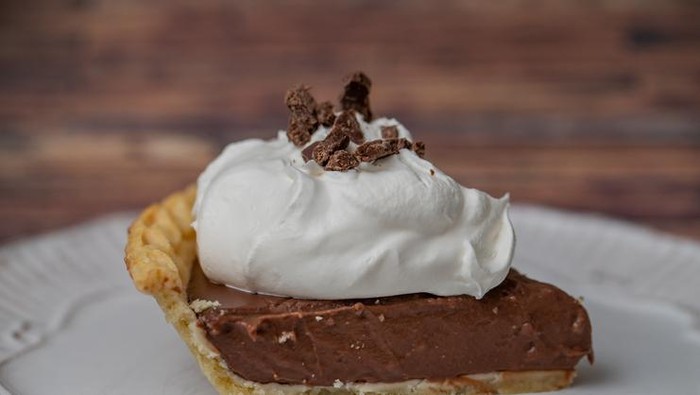 Close up of a slice of chocolate cream pie with whipped cream