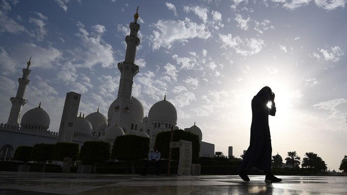 A picture taken on November 6, 2018 shows a visitor in front of the Sheikh Zayed Grand Mosque in the Emirati capital Abu Dhabi. (Photo by GIUSEPPE CACACE / AFP)