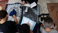 Harun Ahmad bersama anaknya, Taha, Musa dan Isa melakukan tadarus Alquran setelah Shalat Ashar, di rumahnya di Sydney, Australia (9/5/2020).   Lisa Maree Williams/Getty Images