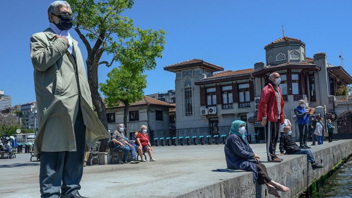 Elderly people wearing a protective face mask, sit and look at the Bosphorus on May 10, 2020, at Besiktas, Istanbul, after a month and a half of lockdown restrictions aimed at stemming the spread of the novel coronavirus. -  (Photo by Bulent Kilic / AFP)