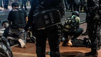 Seorang pengunjuk rasa anti-pemerintah ditahan oleh polisi di sebuah jalan saat demonstrasi di distrik Mongkok.