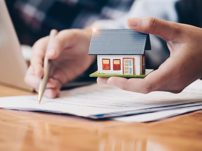 Desain Rumah Viral Close up real estate agent with house model hand putting signing contract,have a contract in place to protect it,signing of modest agreements form in office.Concept real estate,moving home or renting property