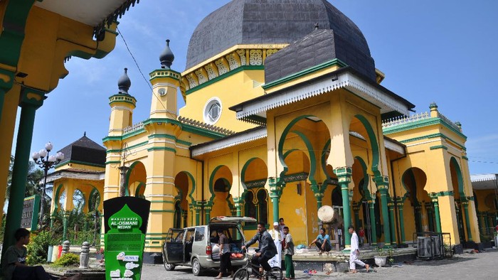 Sejumlah warga berada di depan Masjid Raya Al Osmani Medan, Sumatera Utara, Senin (11/5/2020). Masjid yang dibangun pada tahun 1854 oleh Raja Kesultanan Melayu Deli tersebut merupakan masjid tertua di Kota Medan dengan gaya berarsitektur Eropa, Persia dan China. ANTARA FOTO/Septianda Perdana/hp.