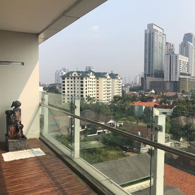 Penghuni bisa menikmati city view lewat balkon kaca yang langsung menghadap ke pemandangan gedung-gedung pencakar langit Jakarta.  Apartemen ini berada di lantai 7. Foto: Instagram/@vennamelindareal