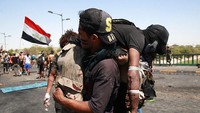 Seorang pengunjuk rasa anti-pemerintah yang terluka dilarikan ke rumah sakit saat berlangsungnya bentrokan di Baghdad, Irak. 