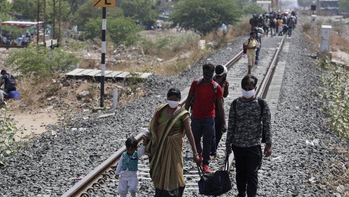 Para pekerja di Ahmedabad pulang kampung dengan menyusuri rel kereta api (AP News)