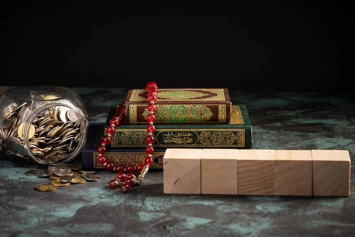 Islamic concept: The holy Quran and Tasbih (rosary beads) on dark background