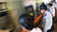 Sejumlah petugas Dinas Perhubungan DKI Jakarta beserta petugas PT Kereta Api Indonesia (KAI) memberi salam pada rangkaian kereta api luar biasa relasi Gambir-Surabaya Pasar Turi lintas selatan yang berangkat di Stasiun Gambir, Jakarta. ANTARA FOTO/M Risyal Hidayat