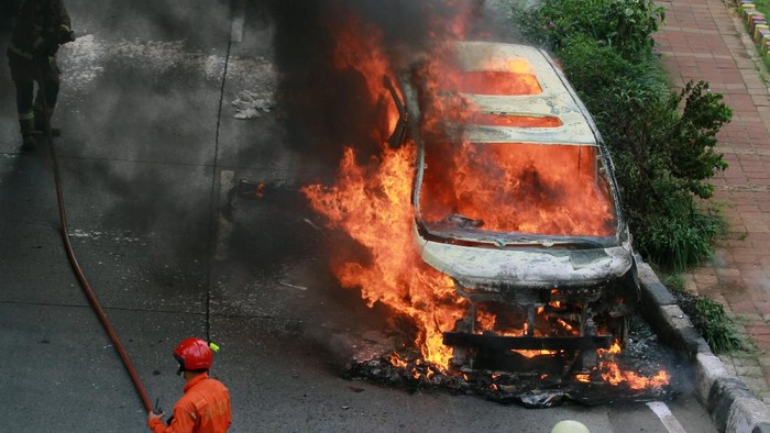Petugas Sudin pemadam kebakaran Jakarta Selatan mencoba memadamkan api yang membakar mobil mewah jenis Toyota Vellfire di Jalan Sultan Iskandarsyah, Pondok Indah, Jakarta, Senin (11/5/2020). Api yang membakar mobil mewah tersebut diduga berasal dari korsleting arus listrik mobil dan tidak ada korban jiwa dalam peristiwa tersebut. ANTARA FOTO/Muhammad Iqbal/hp.