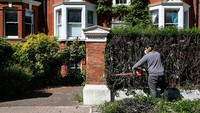 Tukang kebun merawat tanaman di pemukiman mewah di distrik Battersea, London (12/5/2020). Harga rumah mewah mengalami dampak signifikan akibat pandemi Corona yang terus memperlambat pertumbuhan ekonomi.