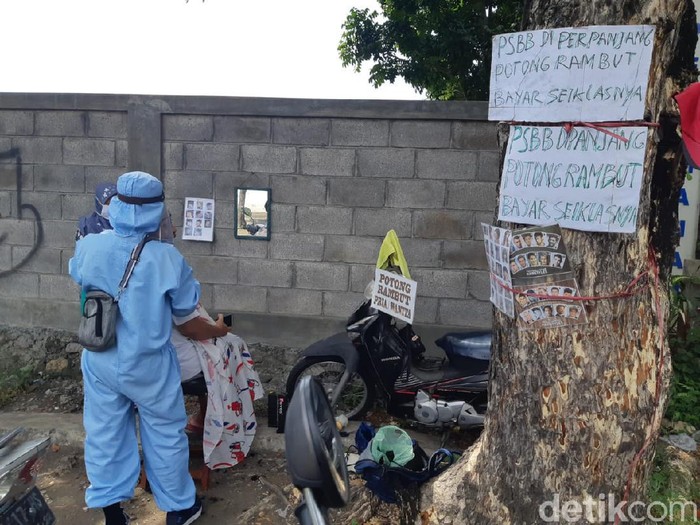 Foto tukang cukur keliling di Surabaya viral di media sosial. Tukang cukur tersebut mencuri perhatian karena menggunakan APD tenaga medis.