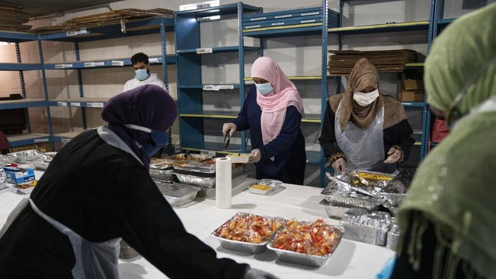Relawan mendistribusikan makanan nutuk orang-orang berbuka puasa di Columbia Heights, Pakistan, beberapa waktu lalu.