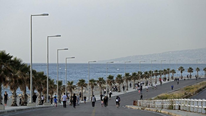 Lebanese people exercise on an empty road by the Dbayeh seaside promenade at the northern entrance of the capital Beirut, after the easing of lockdown measures established to curb the spread of the COVID-19 pandemic, on May 8, 2020. (Photo by JOSEPH EID / AFP)