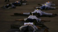 Perawat berbaring di tanah untuk mewakili rekan-rekan yang tewas dalam perjuangan mereka melawan pandemi COVID-19, di Brasilia, Brasil, Selasa, 12 Mei 2020.