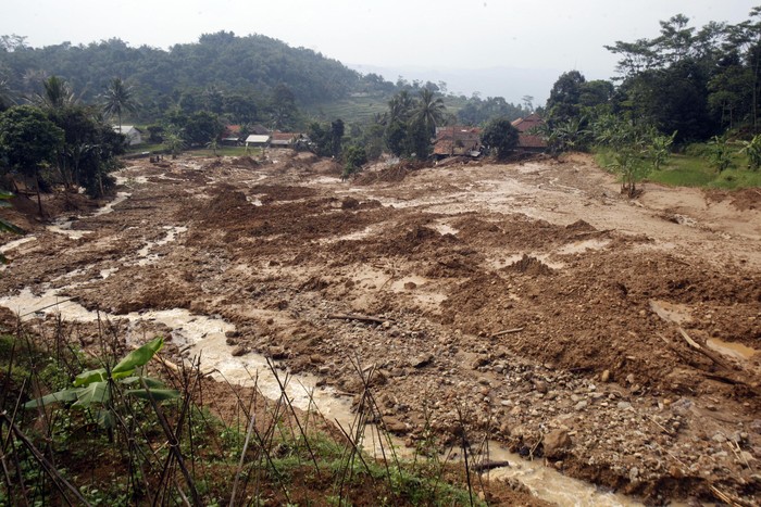 Warga melihat kondisi lokasi tanah longsor dan banjir bandang di Kampung Suruluk, Desa Wangunjaya, Leuwisadeng, Kabupaten Bogor, Jawa Barat, Rabu (13/5/2020).  BPBD Kabupaten Bogor menyatakan peristiwa banjir bandang  disertai longsor  akibat hujan deras  yang terjadi pada malam hingga pagi hari, dan mengakibatkan 14 rumah rusak parah serta satu orang meninggal dunia. ANTARA FOTO/Yulius Satria Wijaya/foc.