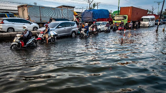 Kendaraan bermotor menembus jalan raya pantura Demak KM 8 ruas Demak-Semarang yang terendam limpasan air laut ke daratan (rob) di Demak, Jawa Tengah, Rabu (13/5/2020). Banjir rob yang melimpas ke jalur utama pantura Demak setinggi sekitar 15-40 sentimeter itu menyebabkan kemacetan lalu lintas sepanjang sekitar 7,5 kilometer dari arah Kabupaten Demak menuju Kota Semarang dan sepanjang sekitar satu kilometer dari arah Kota Semarang menuju Kabupaten Demak. ANTARA FOTO/Aji Styawan/foc.