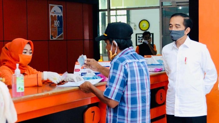 Presiden Joko Widodo (Jokowi) meninjau penyerahan bantuan tunai kepada sejumlah keluarga penerima manfaat yang digelar di Kantor Pos Jalan Ir. H. Juanda, Kota Bogor, pada Rabu, 13 Mei 2020. Bantuan tunai tersebut diberikan kepada masyarakat agar tetap memiliki daya beli di tengah pandemi Covid-19.