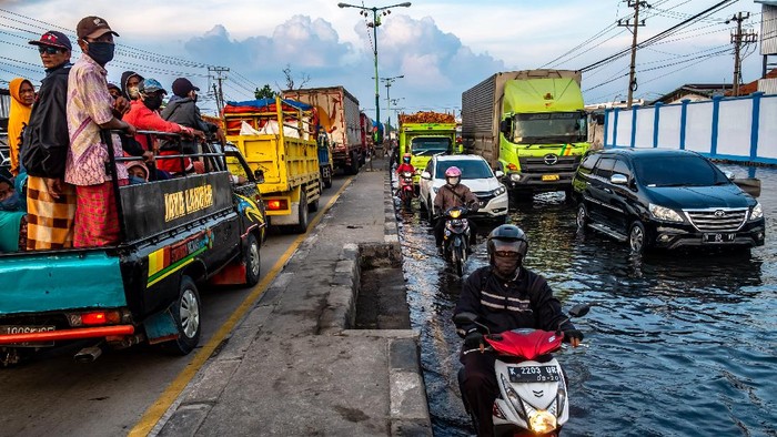 Kendaraan bermotor menembus jalan raya pantura Demak KM 8 ruas Demak-Semarang yang terendam limpasan air laut ke daratan (rob) di Demak, Jawa Tengah, Rabu (13/5/2020). Banjir rob yang melimpas ke jalur utama pantura Demak setinggi sekitar 15-40 sentimeter itu menyebabkan kemacetan lalu lintas sepanjang sekitar 7,5 kilometer dari arah Kabupaten Demak menuju Kota Semarang dan sepanjang sekitar satu kilometer dari arah Kota Semarang menuju Kabupaten Demak. ANTARA FOTO/Aji Styawan/foc.