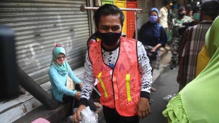 SANKSI SOSIAL PELANGGAR PSBB JAKARTA Seorang warga yang terjaring razia penindakan pelanggaran aturan Pembatasan Sosial Berskala Besar (PSBB) oleh Satpol PP menjalani hukuman dengan cara membersihkan sampah di Tanah Abang, Jakarta, Rabu (13/5/2020). Pemprov DKI Jakarta mulai memberlakukan sanksi sosial terhadap pelanggar PSBB yaitu dengan memakaikan rompi bertuliskan pelanggar PSBB saat mereka membersihkan fasilitas umum. ANTARA FOTO/Akbar Nugroho Gumay/aww.