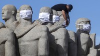 Seorang pekerja kota mengenakan masker di Monumento as Bandeiras, sebuah monumen untuk menghormati penjajah Brasil oleh pematung Italia-Brasil Victor Brecheret, untuk mempromosikan pemakaian masker di tengah pandemi virus corona baru di Sao Paulo, Brasil, Selasa, 12 Mei 2020.