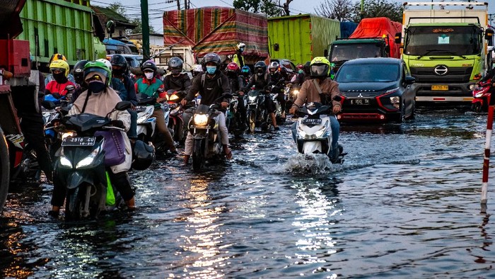 Kendaraan bermotor menembus jalan raya pantura Demak KM 8 ruas Demak-Semarang yang terendam limpasan air laut ke daratan (rob) di Demak, Jawa Tengah, Rabu (13/5/2020). Banjir rob yang melimpas ke jalur utama pantura Demak setinggi sekitar 15-40 sentimeter itu menyebabkan kemacetan lalu lintas sepanjang sekitar 7,5 kilometer dari arah Kabupaten Demak menuju Kota Semarang dan sepanjang sekitar satu kilometer dari arah Kota Semarang menuju Kabupaten Demak. ANTARA FOTO/Aji Styawan/foc.