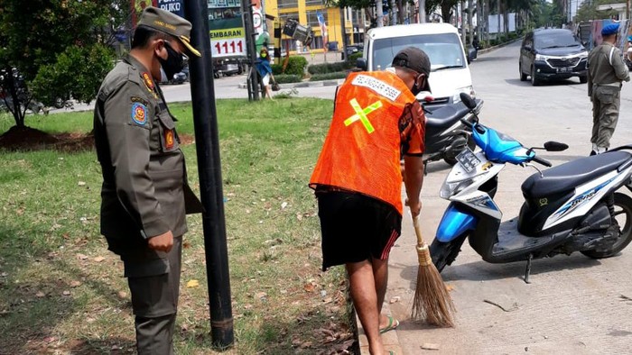 Pelanggar PSBB di Jakarta Barat diberikan sanksi kerja sosial menyapu.