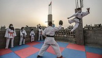 Para karateka di Palestina melakukan latihan di atas roof top rumah untuk mematuhi peraturan protokol kesehatan dengan melakukan kegiatan dirumah saja.  Mohammed Talatene/picture alliance via Getty Images.