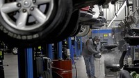 Elliot Nelson menyemprotkan disinfektan pada sebuah toko reparasi mobil di Kansas, Amerika Serikat.