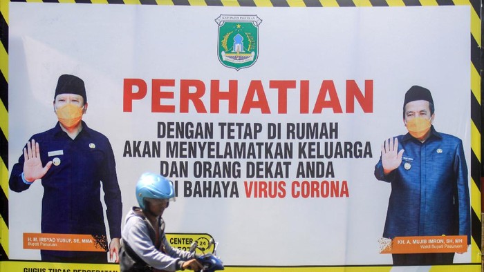 HIMBAUAN BERAKTIVITAS DI RUMAH Pengendara melintas di spanduk imbauan terkait bahaya Virus Corona (COVID-19) di Pasuruan, Jawa Timur, Selasa (14/4/2020). Pemerintah Kota Pasuruan terus melakukan upaya preventif untuk mencegah penyebaran virus corona (COVID-19) dengan memasang sejumlah spanduk di jalan. ANTARA FOTO/Umarul Faruq/hp.