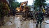 Alat berat yang dikerahkan Badan Penanggulangan Bencana Daerah (BPBD) dibantu aparat TNI dan Polri membersihkan jalan dan rumah warga dari material kayu dan batu akibat banjir bandang di Desa Paya Tumpi Baru, Kecamatan Kebayakan, Aceh Tengah, Aceh.