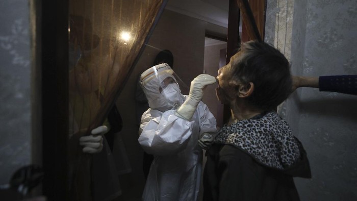 A medical worker takes a swab from a resident for the coronavirus test during home visits in Wuhan the epicenter of Chinas coronavirus outbreak in central Chinas Hubei province, Thursday, May 14, 2020. Some residential compounds in Wuhan have begun testing inhabitants for the coronavirus as a program to test everyone in the Chinese city of 11 million people in 10 days got underway. (Chinatopix via AP)