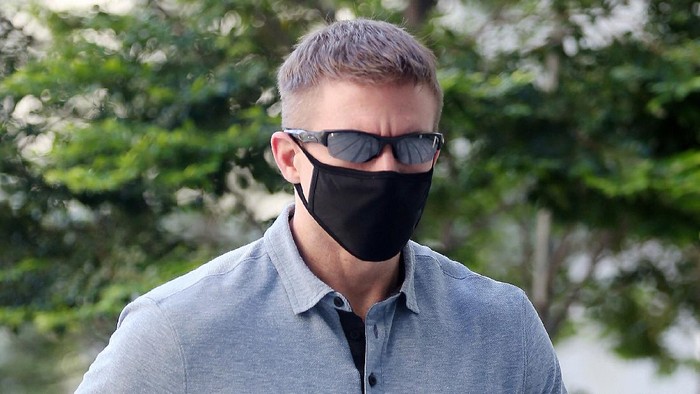 CORRECTS SOURCE - In this May 13, 2020, photo, Brian Dugan Yeargan, wearing a face mask and sunglasses, walks outside the Singapore State Court in Singapore. The 44-year-old American pilot has been jailed for four weeks for breaching a quarantine order in Singapore. Local media reported that Brian Dugan Yeargan was sentenced by a court Wednesday, May 13 for leaving his hotel room for three hours to buy masks and a thermometer.  (The Straits Times via AP)