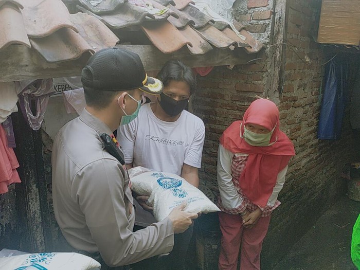 Polisi di Kecamatan Genteng, Surabaya membagikan puluhan paket beras. Mereka menyasar warga terdampak Corona yang belum mendapat bantuan.
