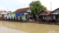 Personel Brimob menyusuri gang di pinggir sungai di Kampung Sukasari, Desa Mekarpawitan, Kecamatan Paseh, Kabupaten Bandung.