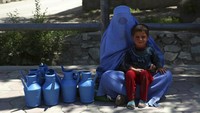 Penjual teko air plastik menjajakan dagangannya di jalanan Kabul,  Afghanistan (5/5/2020).  Kemiskinan dan konflik membuat Afghanistan makin terperosok di masa sulit pandemi Corona. AP Photo/Rahmat Gul