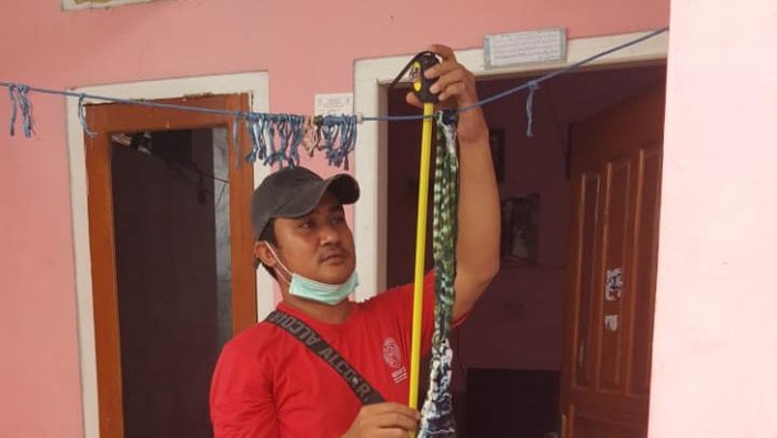 Polisi mengukur ketinggian jemuran yang digunakan untuk menggantung korban