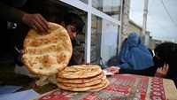 Pembagian sedekah roti gratis di Kabul, Afghanistan (29/4/2020). Pemerintah Afghanistan memberlakukan lockdown nasional untuk menghadapi pandemi COVID-19.  WAKIL KOHSAR/AFP/ Getty Images