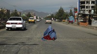 Perempuan berburqa menanti sedekah Ramadan di tengah jalanan  di Kabul, Afghanistan (3/5/2020). WAKIL KOHSAR/AFP/ Getty Images