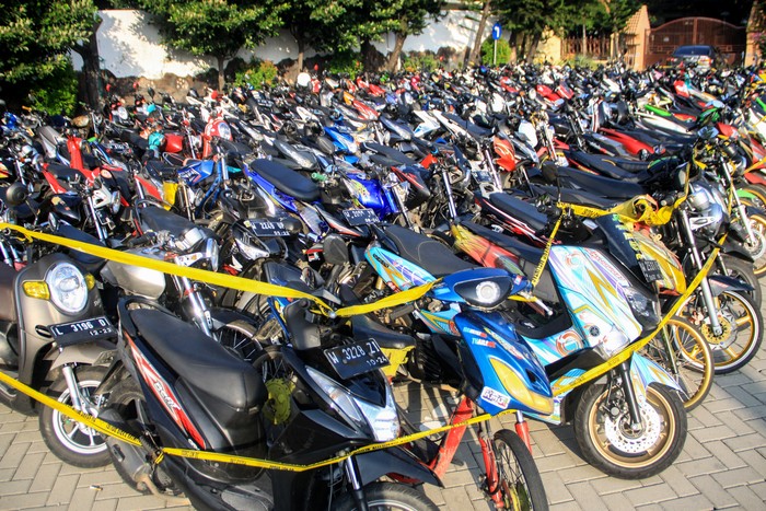 Ratusan kendaraan bermotor milik warga yang terjaring razia terparkir di halaman Polresta Sidoarjo, Jawa Timur, Minggu (17/5/2020). Kepolisian Resor Kota Sidoarjo Jawa Timur berhasil mengamankan 224 kendaraan bermotor yang diduga digunakan saat balap liar motor di akses jalan exit tol porong saat pemberlakuan pembatasan sosial berskala besar (PSBB) dan melakukan pembinaan terhadap 500 pemuda yang turut terjaring dalam razia itu agar tidak mengulangi perbuatannya. ANTARA FOTO/Umarul Faruq/foc.