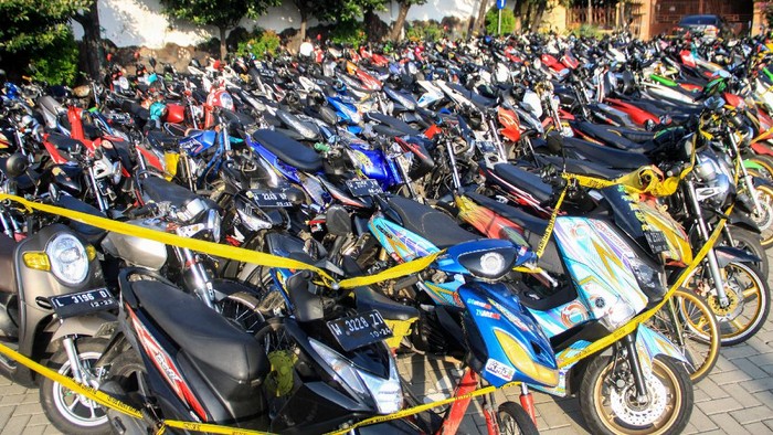 Ratusan kendaraan bermotor milik warga yang terjaring razia terparkir di halaman Polresta Sidoarjo, Jawa Timur, Minggu (17/5/2020). Kepolisian Resor Kota Sidoarjo Jawa Timur berhasil mengamankan 224 kendaraan bermotor yang diduga digunakan saat balap liar motor di akses jalan exit tol porong saat pemberlakuan pembatasan sosial berskala besar (PSBB) dan melakukan pembinaan terhadap 500 pemuda yang turut terjaring dalam razia itu agar tidak mengulangi perbuatannya. ANTARA FOTO/Umarul Faruq/foc.