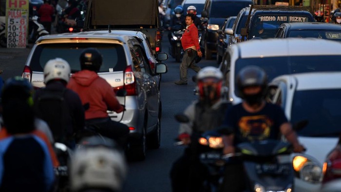 Pengendara motor dan mobil antre melintas saat terjadi keramaian lalu lintas di Jalan Raya Sawangan, Depok, Jawa Barat, Sabtu (16/5/2020). Meski penerapan Pembatasan Sosial Berskala Besar (PSBB) Kota Depok masih diperpanjang hingga 26 Mei 2020, namun sejumlah ruas jalan mulai ramai dipadati kendaraan hingga menyebabkan kemacetan. ANTARA FOTO/Sigid Kurniawan/wsj.